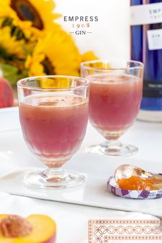 two glasses filled with liquid sitting on top of a table