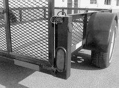 a black and white photo of a dog in the back of a trailer