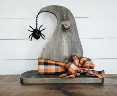 a wooden sculpture with a spider hanging from it's side