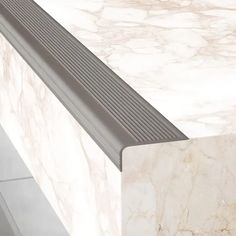 a white marble counter top with metal grates on the bottom and side paneling