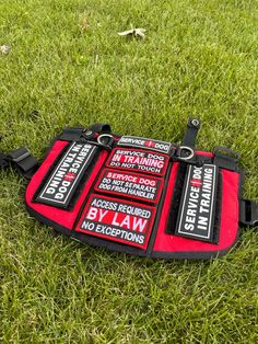 a red and black sign laying on top of green grass next to a frisbee