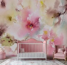 a baby's room decorated in pink and yellow with flowers on the wall behind it