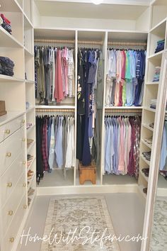 an organized closet with clothes hanging on the walls and drawers, along with a rug