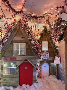 a christmas scene with a gingerbread house and candy canes hanging from the ceiling