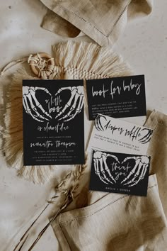 two black and white wedding stationery cards on top of a table with dried flowers