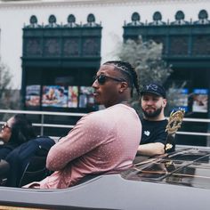 two people sitting on top of a car in front of a building