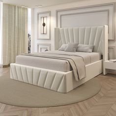 a large white bed sitting on top of a wooden floor