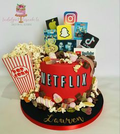 a red cake with popcorn, movies and other items on it