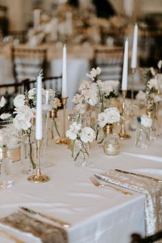 the table is set with white flowers and candles