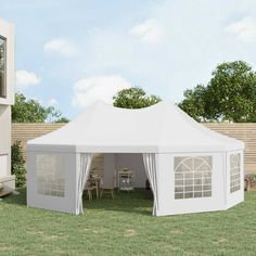 a large white tent sitting on top of a lush green field