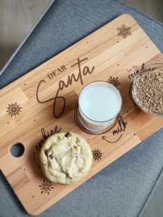 a wooden cutting board topped with cookies and milk