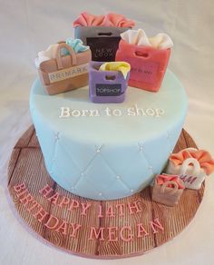 a birthday cake decorated with shopping bags and shoes