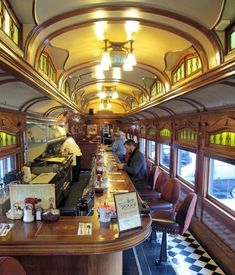 the inside of a train car with people sitting at tables