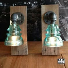 two glass lamps sitting on top of a wooden table