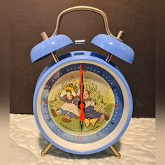 an alarm clock with the image of alice and wonderland on it's face is shown