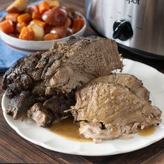 a plate with meat, potatoes and carrots next to an instant pot roaster