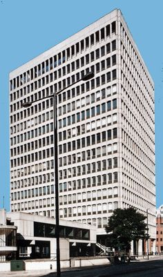 a tall white building sitting on the side of a road next to a street light