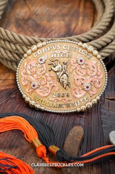 Corpus Buckle  has a Jewelers Bronze base with a beaded border. It is adorned with Copper overlays, Jewelers Bronze lettering, figure and flowers. Senior Class Belt Buckle, Silver Antique Buckle For Western-themed Events, High School Graduation Gifts, Bull Riders, Bull Riding, High School Graduation, School Spirit, Graduation Gifts, Belt Buckles