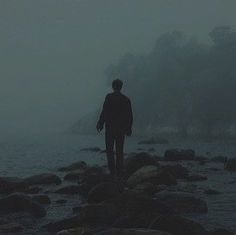 a person standing on rocks in the water