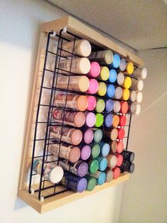 a wooden shelf filled with lots of different types of paint