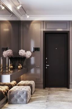 an elegant entryway with modern furniture and flowers