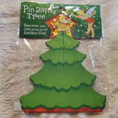 a green christmas tree cutout with tinkerbells on it's top