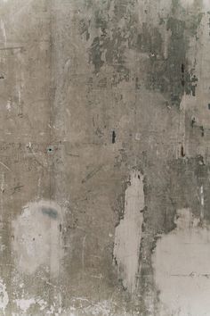 an old wall that has been painted white and gray with some paint chipping off it