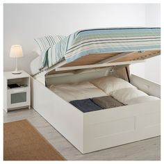 a bed with a pull out storage compartment underneath it