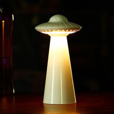 a lamp sitting on top of a wooden table next to a bottle