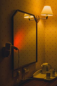 a bathroom with a sink, mirror and light on the wall next to each other