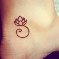 a small tattoo on the ankle of a woman's foot with a red flower