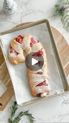 a video demonstrating how to make strawberry hand pies on a baking sheet with rosemary sprigs in the background