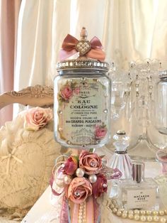 a table topped with lots of glass vases filled with flowers and pearls on top of it