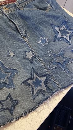 an old pair of blue jean shorts with silver stars on the bottom and sides, sitting on a table