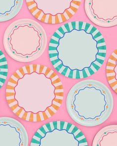 many plates with different designs on them against a pink background