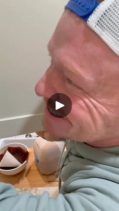 an older man with bandages on his head is eating food from a bowl and spoon