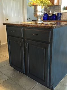 a kitchen island with two blue vases on top