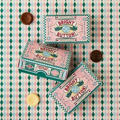 two boxes of bright button candy on a checkered tablecloth