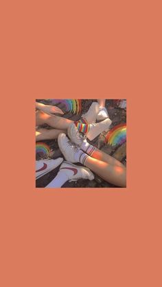 there are many pairs of shoes on the ground with rainbow socks in front of them