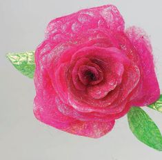 a pink rose with green leaves is shown on a white background and it appears to be made out of yarn