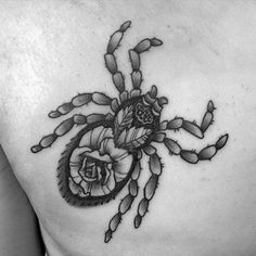 a black and white photo of a woman's chest with a scorpion tattoo on it