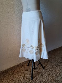 This is a beautifl vintage midi skirt with embroidered floral motifs and  embellished with sequins and beading. Underneath is a petticoat with lace that discreetly comes under the hem. It's in very good condition. Without a composition label, it looks like a solid cotton or linen fabric. It says size L but looks smaller. Please see measurements.  Flat measurements: waist - 37 cm/ 14.5'' hips - 49 cm/19.2'' length - 70 cm/27.5'' Fitted White Skirt With Embroidered Hem, Embroidered Relaxed Flared Skirt, Summer Cream Embroidered Skirt, White Embroidered Bohemian Skirt, Spring Vintage Embroidered Skirt, Vintage Midi Skirt, Embellished Skirt, Embroidered Skirt, Flared Skirt