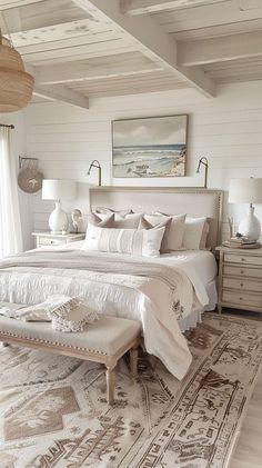 a large white bed sitting in a bedroom next to a window