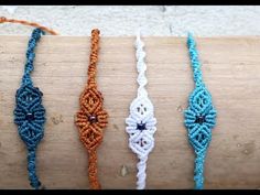 four different bracelets sitting on top of a piece of wood