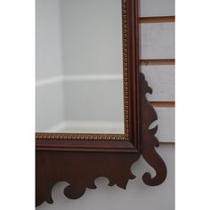 an ornate wooden mirror hanging on the wall