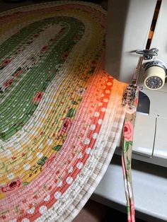 a close up of a sewing machine with a colorful quilt on it's side