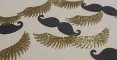 gold and black mustaches with feathers on them