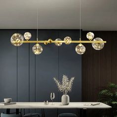 an elegant dining room with black walls and white table, glass balls hanging from the ceiling