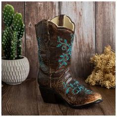 Dimensions: 9.56" H x 8.19" W x 4.18" D Material: Resin Color: Brown, Beige, Turquoise & Gold Pattern: Floral Care & Safety: Not Intended For Use With Water Quantity: 1 Giddyup, cowboy! This attractive Brown & Turquoise Floral Cowboy Boot Vase is sure to inspire some downhome country charm. It features a heavy resin construction in various shades of brown with turquoise floral accents on it. Its faux leather look and stitched detailing make this extremely realistic boot the perfect place to display a faux floral arrangement. Complement your Western decor scheme with this rustic accent. Cowboy Decor Ideas, Western Centerpiece Ideas Cowboy Theme, Cowgirl Party Centerpieces, Western Centerpiece Ideas, Cowboy Party Centerpiece, Cowboy Boot Vase, Western Centerpieces, Boot Vase, Blue Cowboy Boots