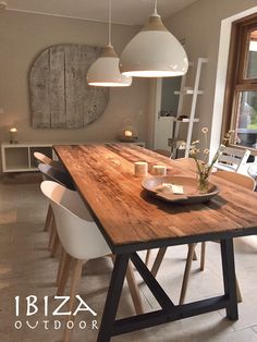 a wooden table with white chairs around it